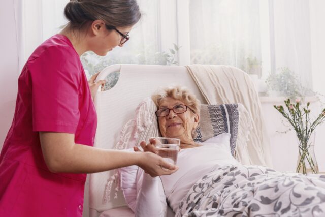 Nurse serving tea to patient.